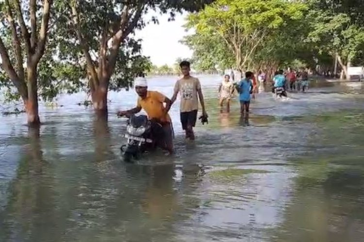 मुख्य सड़क पर बह रहा है 2 फिट से ज्यादा पानी, जान जोखिम में डाल कर लोग कर रहे पार